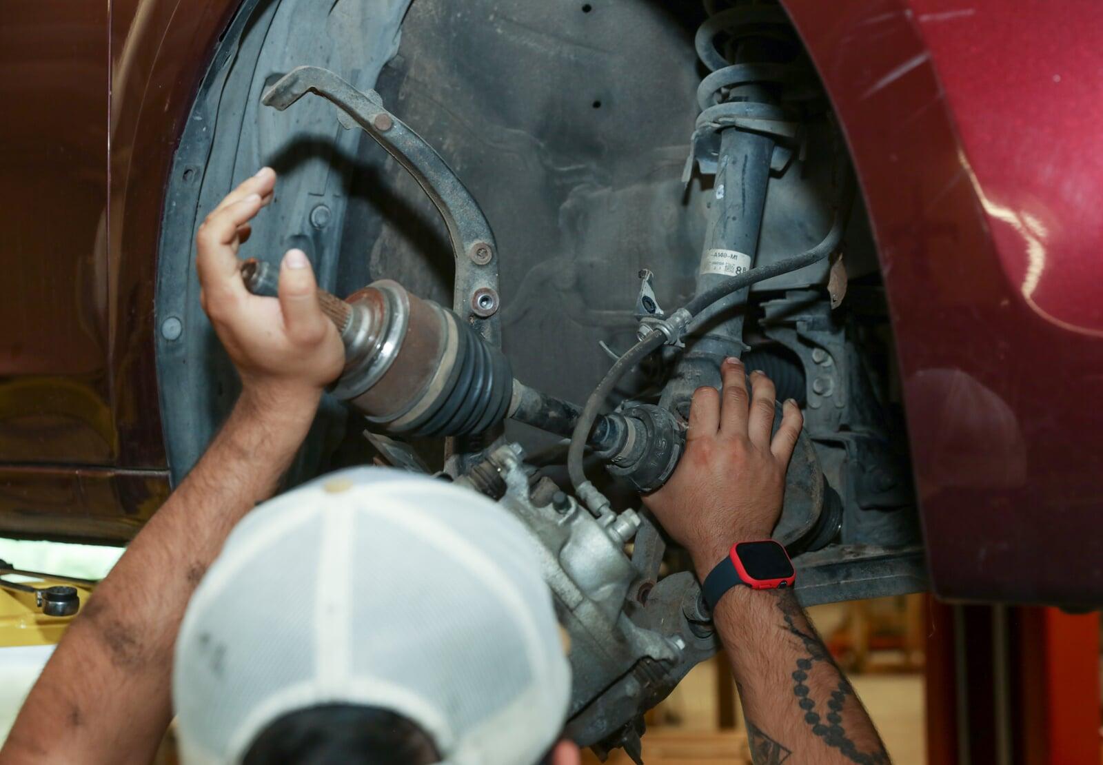 <Bolt Auto Care employee working in a tire well> <Bolt Auto Care employee working in a tire well>