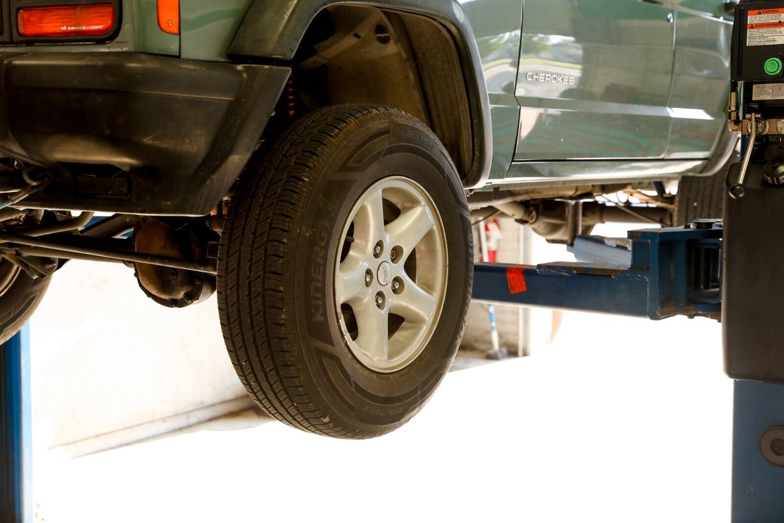 Woman driving car into shop for an oil change. Woman driving car into shop for an oil change.