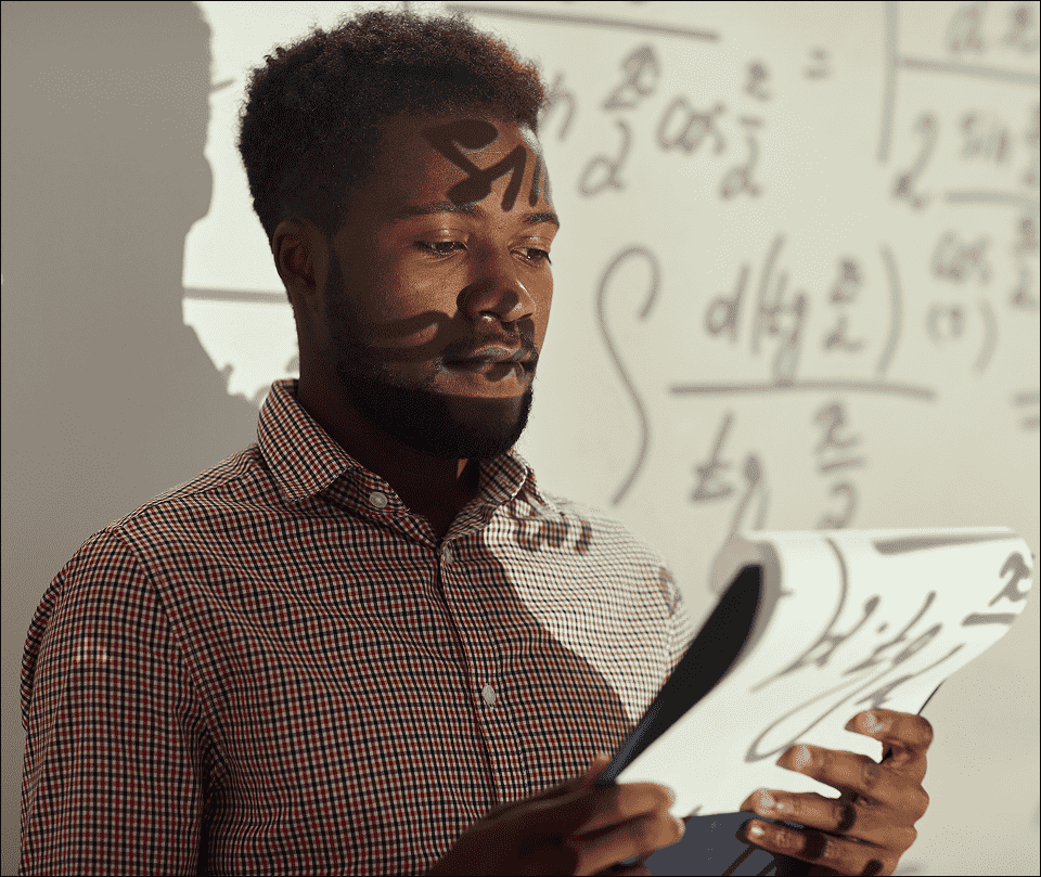 Male teacher holding math text in South Africa for CAPS Maths study guide and exam practice books. Male teacher holding math text in South Africa for CAPS Maths study guide and exam practice books.