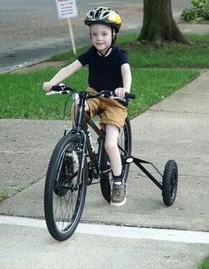 Picture of a boy riding a bike with a set of Large FATWHEELS adaptive training wheels