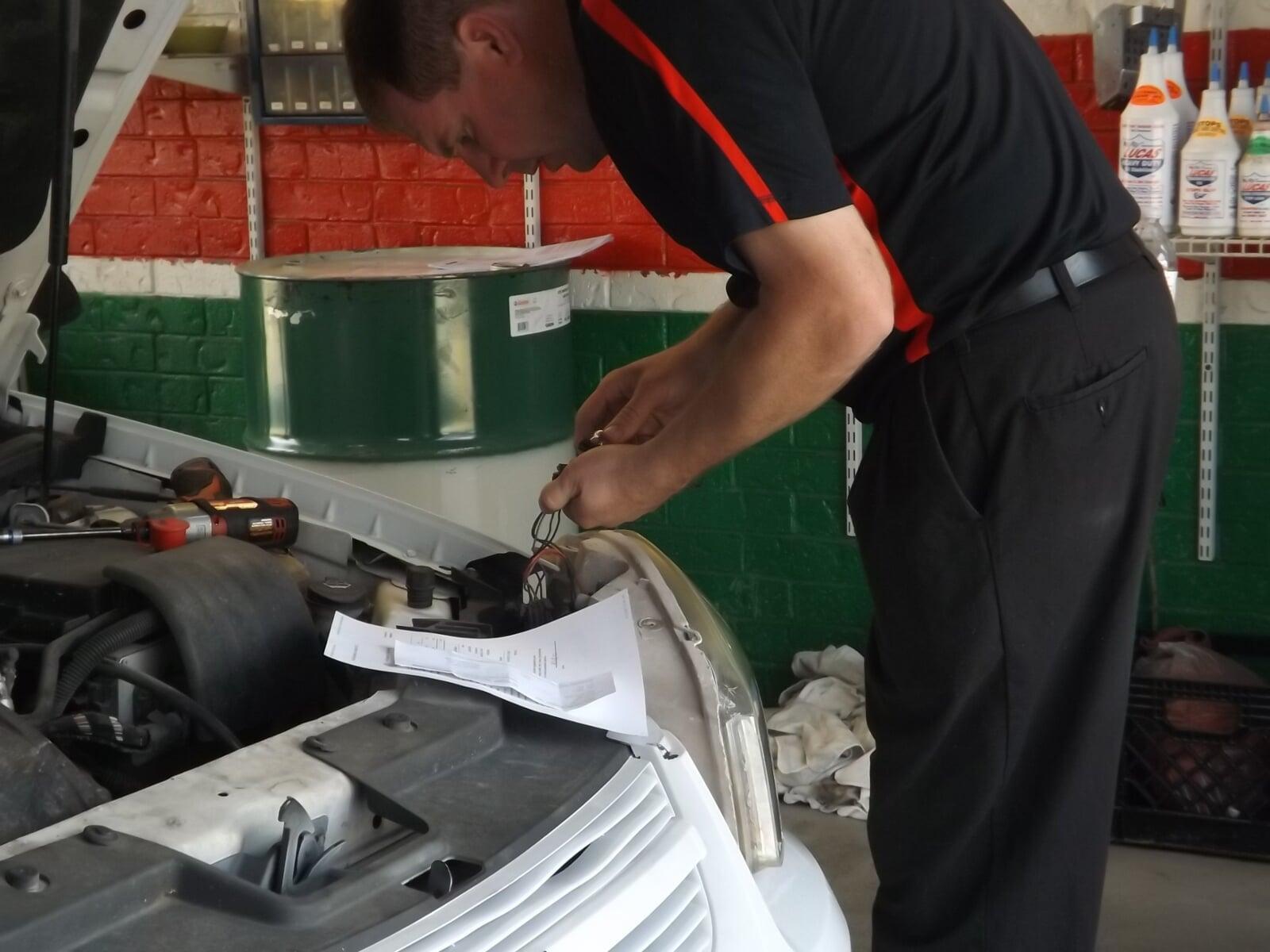 Woman giving a thumbs up while sitting in her car for an oil change.