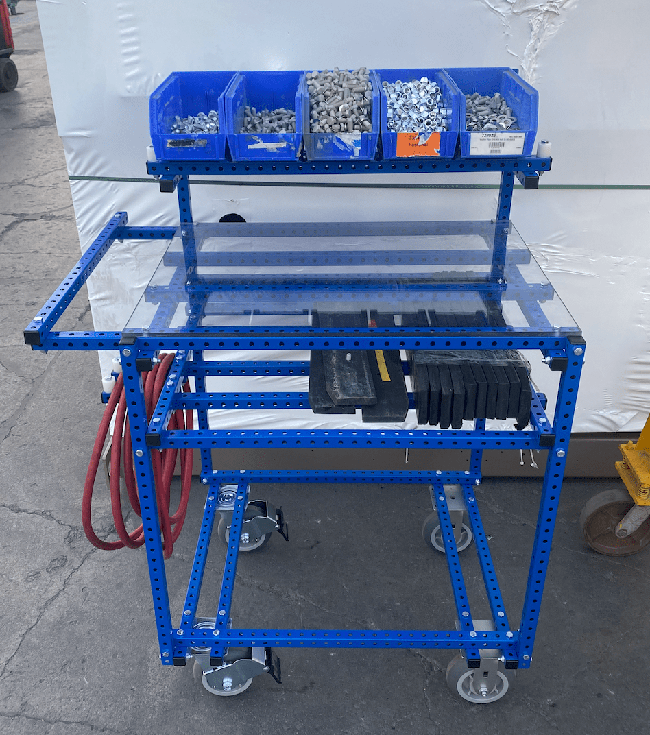 Workstation made with blue tubes of steel, storage bins and lockable casters.