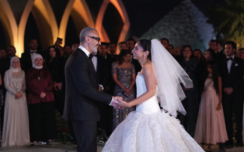 Bride and father dancing at wedding with Pyramids of Giza in the background Bride and father dancing at wedding with Pyramids of Giza in the background