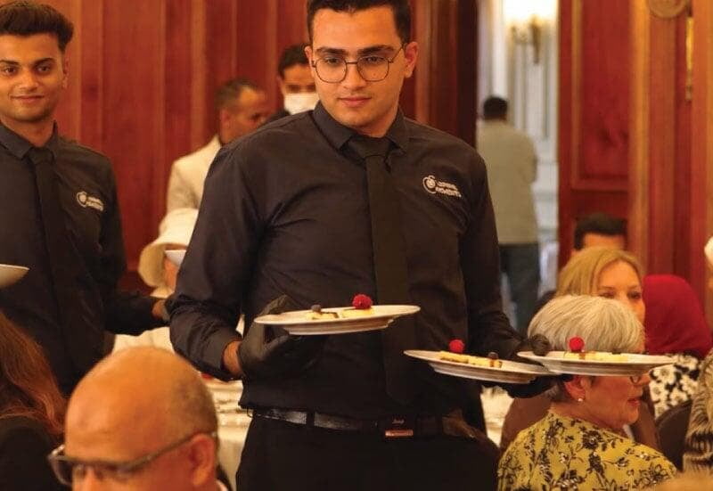 LOriental waiter serving dessert course at BUE seated event LOriental waiter serving dessert course at BUE seated event