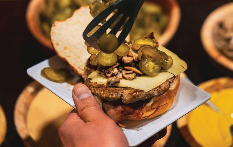 Weding guest adding burger toppings 