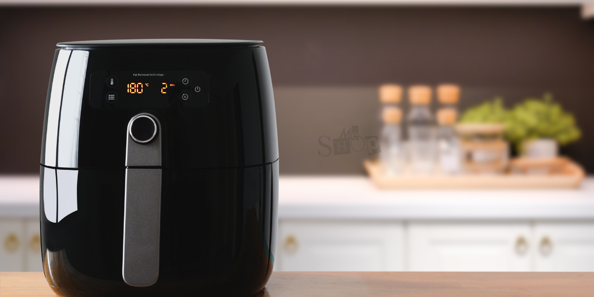 A modern black digital air fryer from Me Shop’s collection. A modern black digital air fryer from Me Shop’s collection.