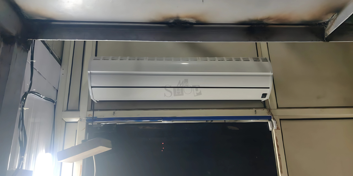 A white Buzz Lite air curtain installed above a shop.