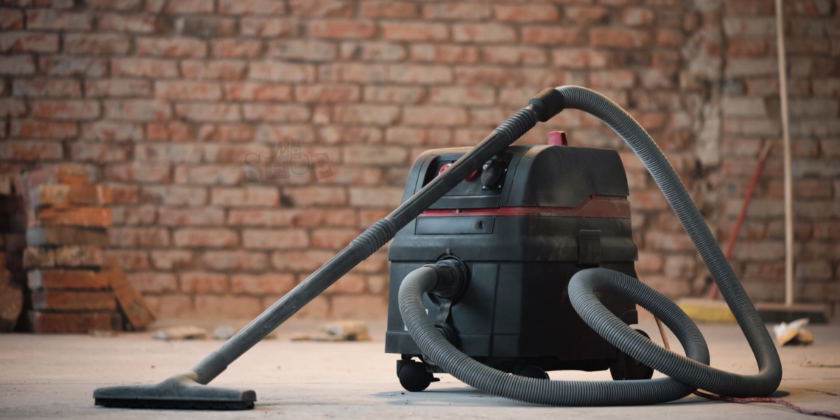 Heavy-duty industrial wet and dry vacuum cleaner on workshop floor.
