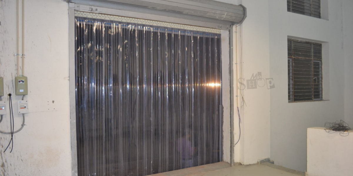 Clear industrial PVC strip curtains in a warehouse doorway. Clear industrial PVC strip curtains in a warehouse doorway.