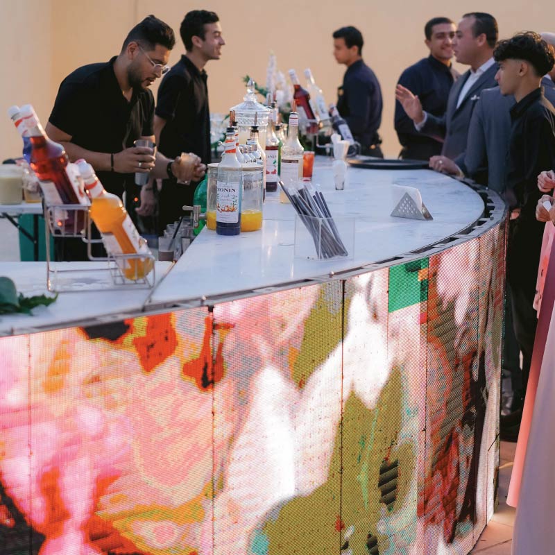 LOriental digital Live Bar with illuminated floral display and guests gathered around the counter at a Dar Darb event in Citadel