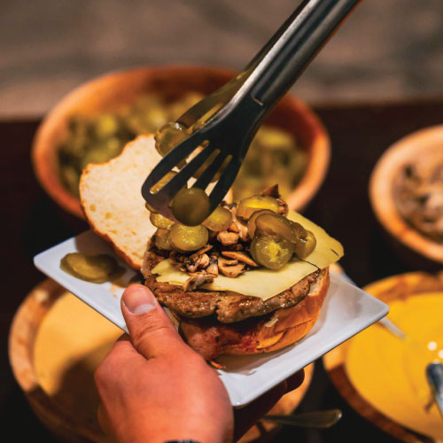 Guest making own burger with toppings choice Guest making own burger with toppings choice