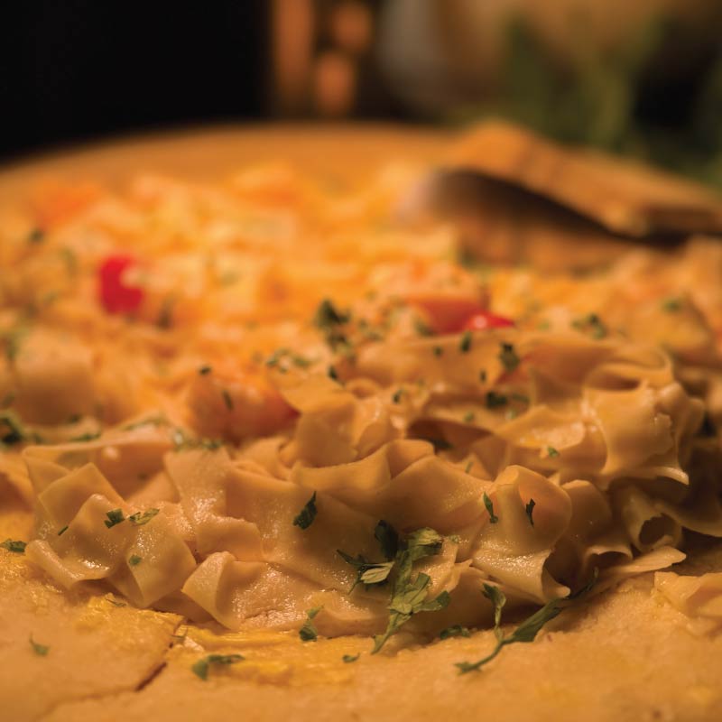 Fresh fettuccine finished inside a Parmesan wheel at a live pasta station Fresh fettuccine finished inside a Parmesan wheel at a live pasta station