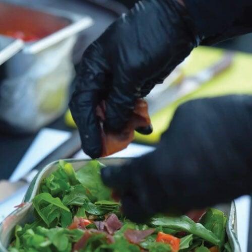 Finishing touches of arugula grison walnut salad, LOriental BOH mobile kitchen Finishing touches of arugula grison walnut salad, LOriental BOH mobile kitchen