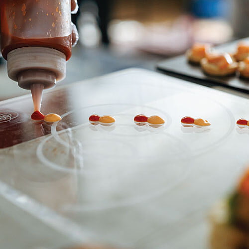 LOriental chef preparing passaround arcylic transparent tray for experiential passaround at Pyramids engagement event