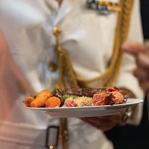 Guest in military outfit holding a plate of food