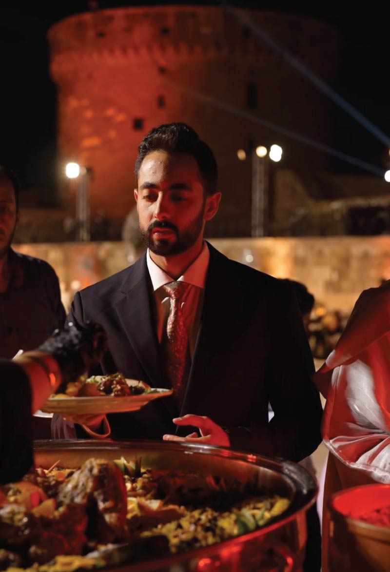 Guest at open buffet getting served food in plate at a wedding in Bir Youssef