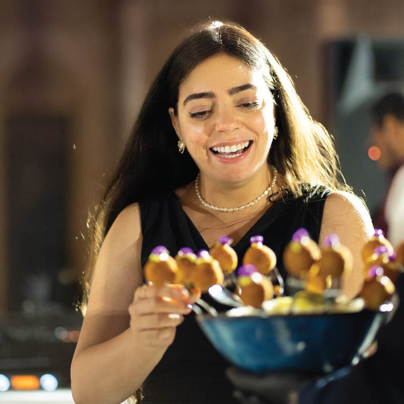 Event guest taking canape from experiential passaround tray Event guest taking canape from experiential passaround tray