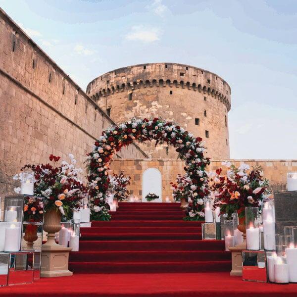 Guest entrance red carpet and floral roman pots at LOriental managed wedding at Bir Youssef Guest entrance red carpet and floral roman pots at LOriental managed wedding at Bir Youssef