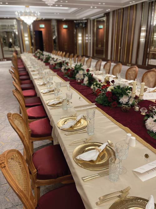Continuous 50-seat dining table with floral centerpiece and candlelight at JW Marriott Cairo