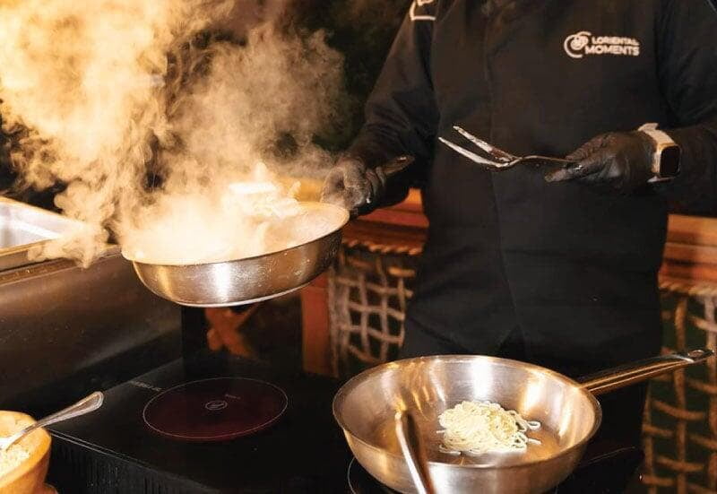 LOriental chef live cooking at an open, hot pan smoke LOriental chef live cooking at an open, hot pan smoke