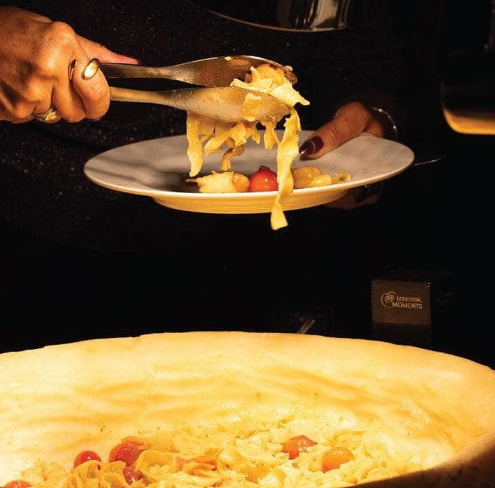 Fresh pasta served from a Parmesan cheese wheel at a LOriental live pasta station