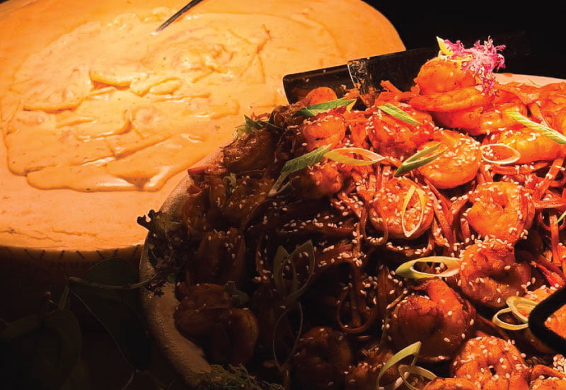Ravioli and honey garlic shrimp on buffet display at a LOriental catered event