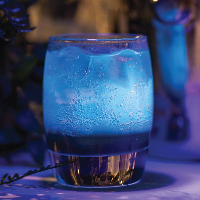 LOriental luminous non-alcoholic cocktail glowing under UV light at a theatrical live bar in Egypt