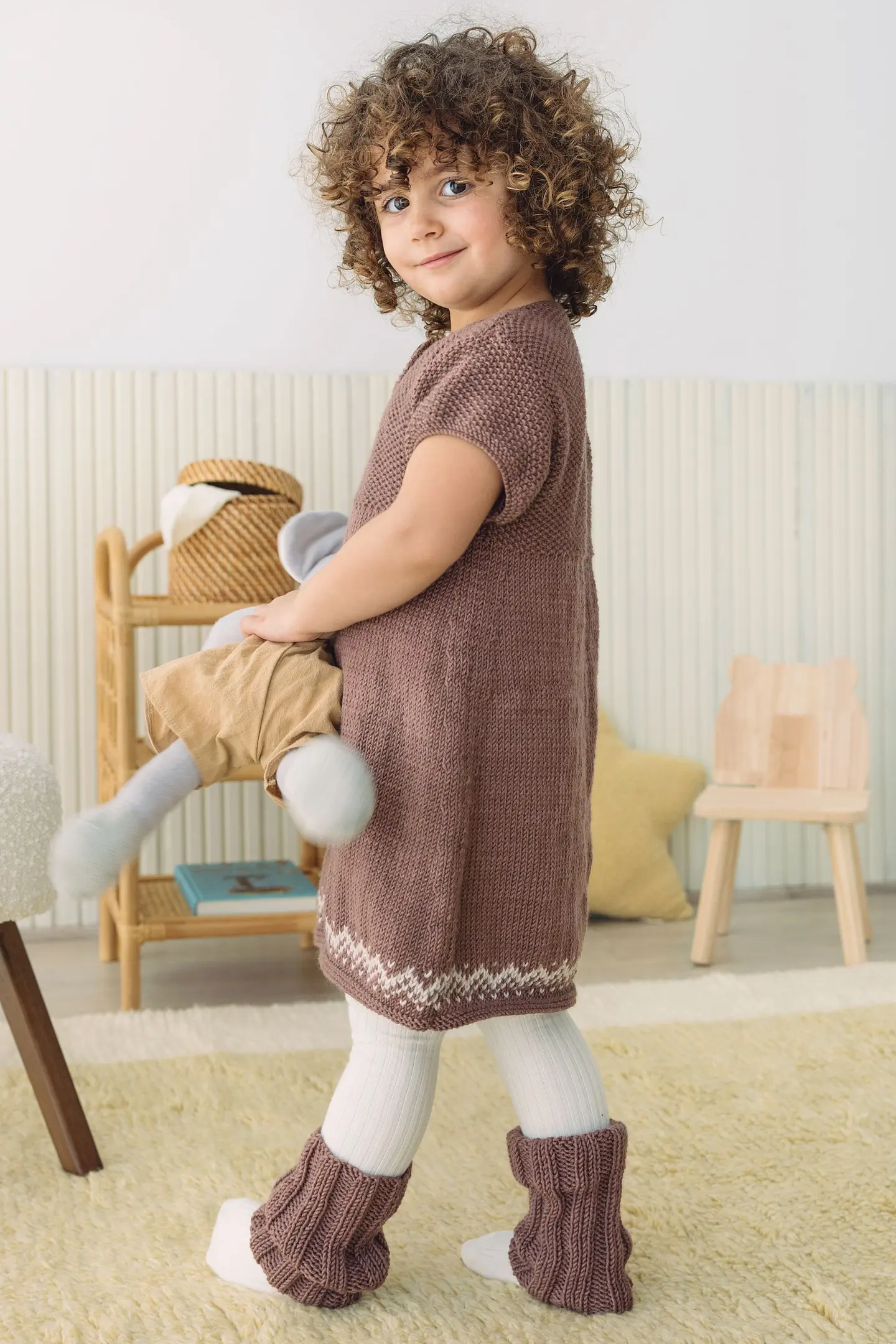 Vestitino realizzato con 100% Baby 4 di DMC. Bimba con pupazzo in mano e
vestitino colore cacao