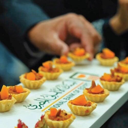 Guest picking up a canape at NBE event in NMEC