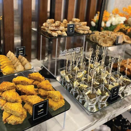 NBE Platinum lounge finger food on buffet with visible NBE branding on food risers NBE Platinum lounge finger food on buffet with visible NBE branding on food risers