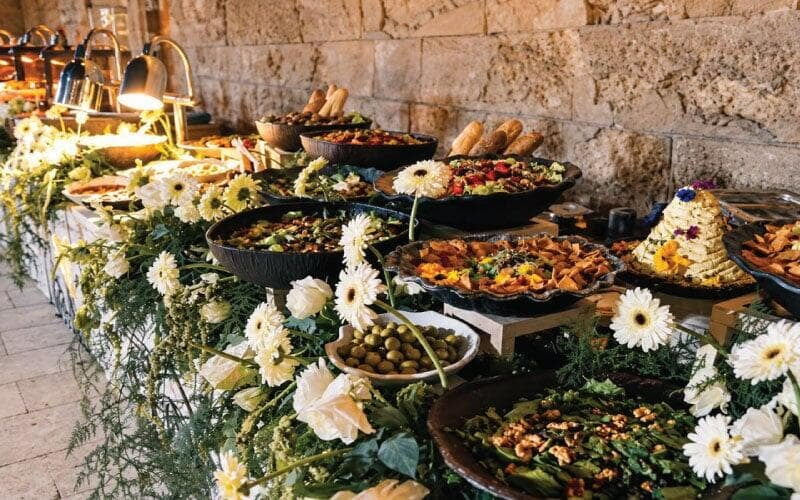 A full dinner open buffet spread showing various salads, a butter tower, and starters at a LOriental event 