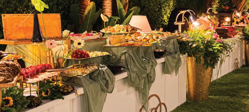 Elegant outdoor open buffet with styled food displays, florals and warm lighting Elegant outdoor open buffet with styled food displays, florals and warm lighting