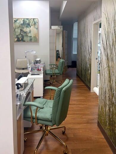 Manicure stations with sage green chairs along the grass-mural hallway at Vancouver Green Spa