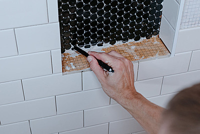 ThinStick grout cleaning and trimming tool being used on wall tile.
