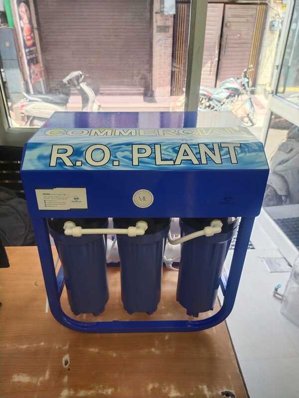 A technician servicing the filter cartridges of the Aqua Cool 25 B unit under a sink.