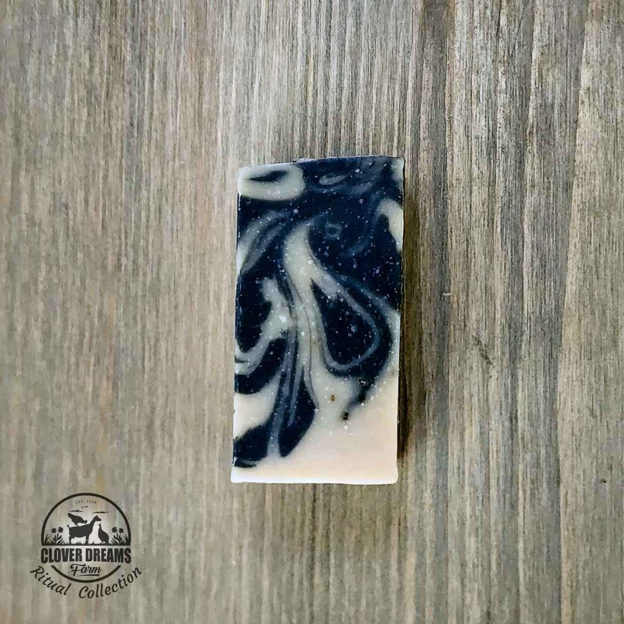Unwrapped Lavender Sage goat milk soap stick with dark blue and cream swirls Unwrapped Lavender Sage goat milk soap stick with dark blue and cream swirls