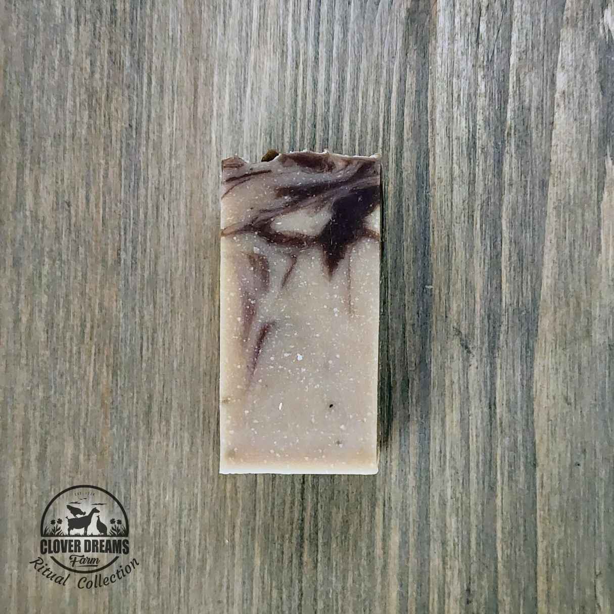 Unwrapped Palo Santo Sage goat milk soap stick with burgundy and cream swirls