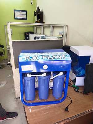 A person filling a glass with pure water from the stylish faucet of the Power Jal Aqua Cool 25 B.