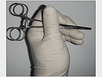 Hold the closed forceps under your thumb for wound packing.