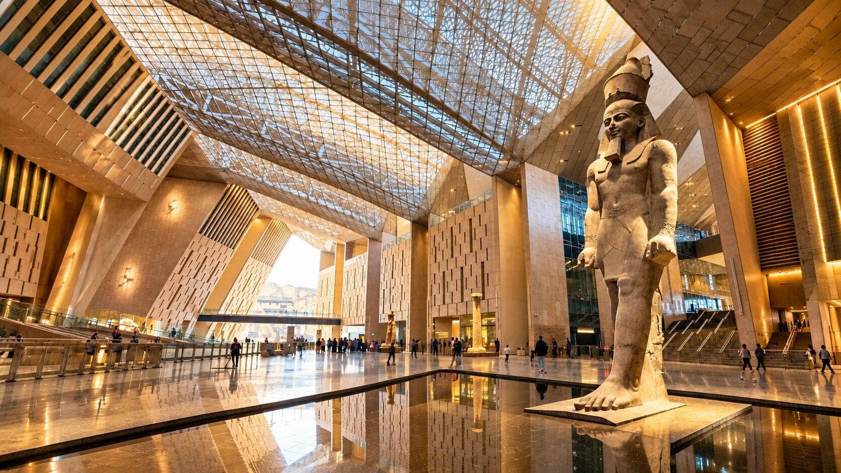 The 11-meter-tall Colossal Statue of Ramesses II carved from red
granite, standing as the centerpiece inside the modern, sunlit Grand
Hall atrium of the Grand Egyptian Museum (GEM) The 11-meter-tall Colossal Statue of Ramesses II carved from red
granite, standing as the centerpiece inside the modern, sunlit Grand
Hall atrium of the Grand Egyptian Museum (GEM)
