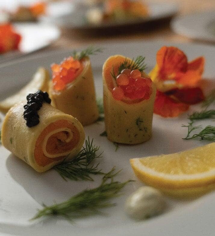 Close-up shot of smoke salmon and caviar crepe roulade starter course at a seated dinner Close-up shot of smoke salmon and caviar crepe roulade starter course at a seated dinner