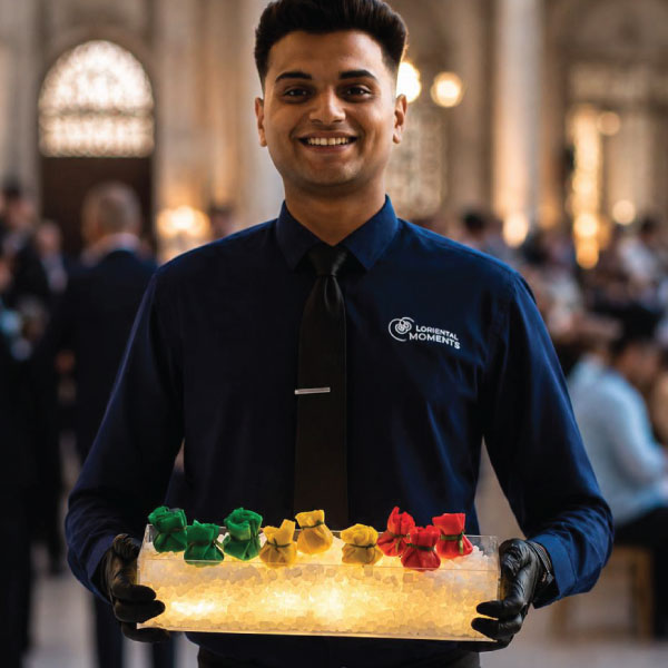 LOriental waiter holding an illuminated theatrical presentation platform at Mohamed Ali Court