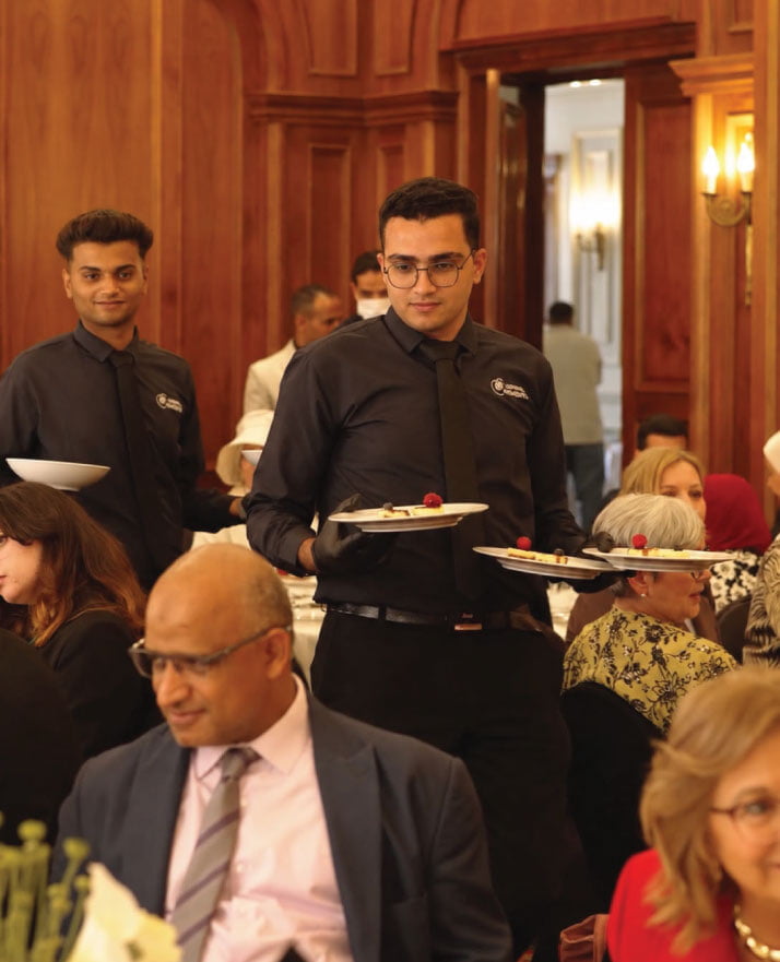 LOriental waiters serving dessert course at seated lunch event at the British University in Egypt LOriental waiters serving dessert course at seated lunch event at the British University in Egypt