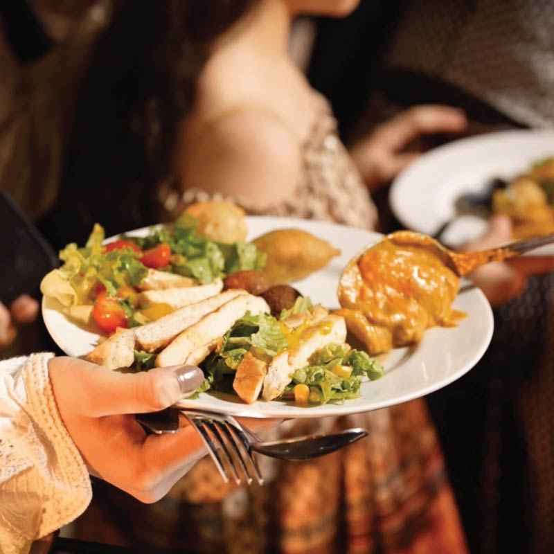 Guest at wedding buffet with plate of food